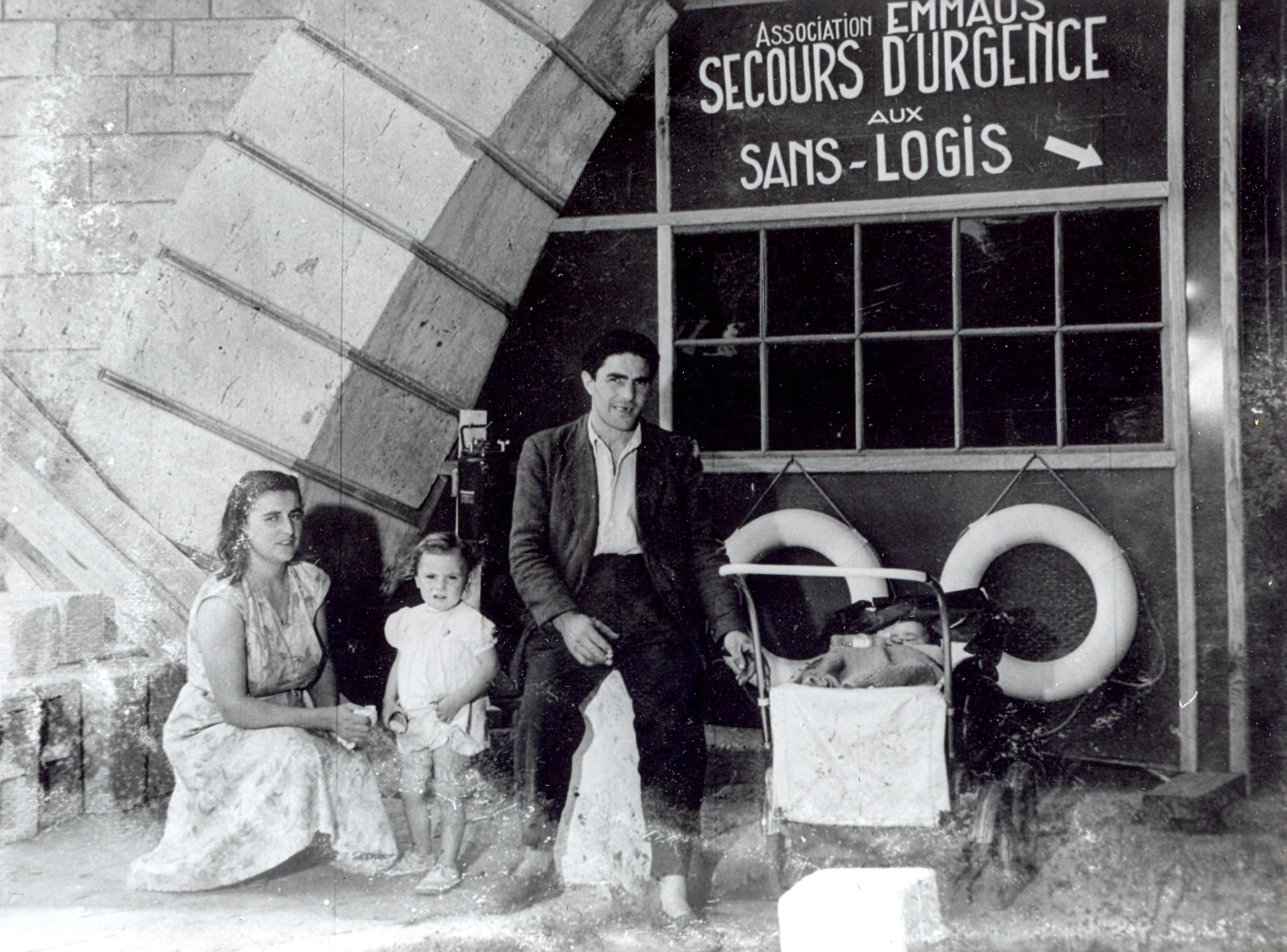 Famillle au camp d'acceuil d'urgence d'Emmaüs installé sous le pont Sully à Paris, août 1955. ©Emmaüs International